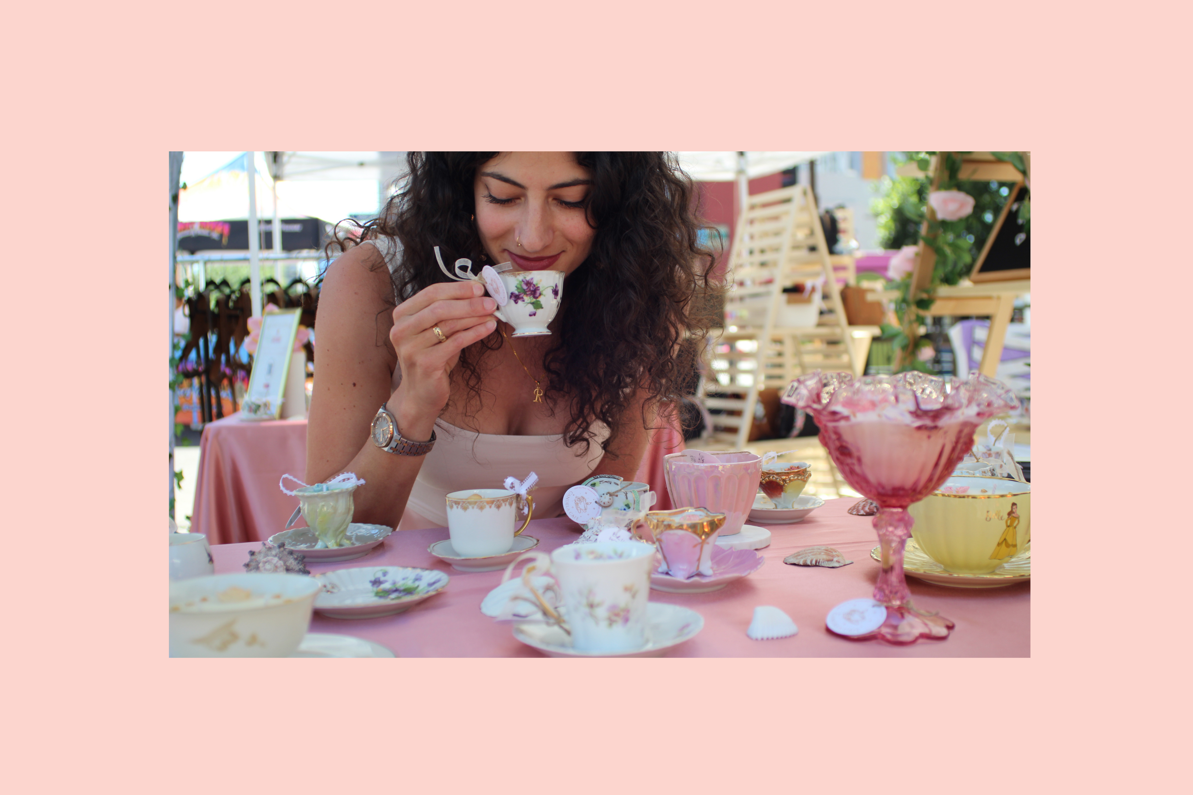 Woman smelling boutique and vintage teacup candles from Candela Cafe